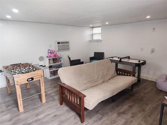 living room with a wall mounted air conditioner and hardwood / wood-style floors