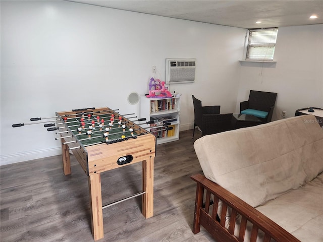 rec room featuring dark wood-type flooring and a wall mounted air conditioner