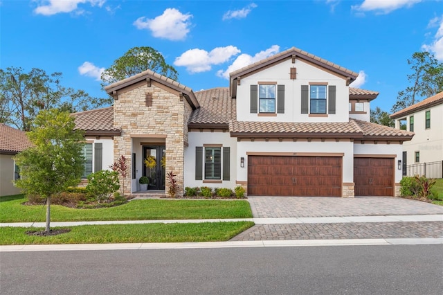 mediterranean / spanish home with a garage and a front yard