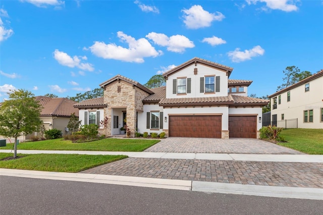 mediterranean / spanish-style home featuring a garage and a front yard