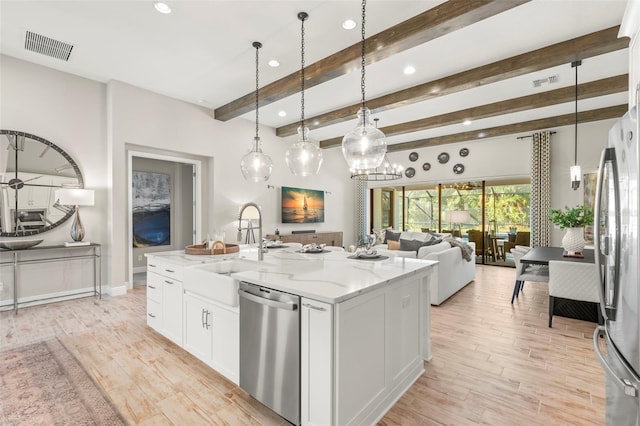 kitchen featuring white cabinetry, appliances with stainless steel finishes, a kitchen island with sink, and decorative light fixtures