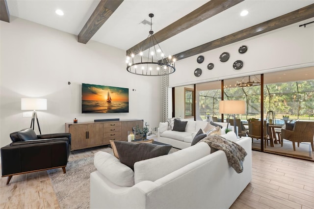 living room with beamed ceiling, light hardwood / wood-style flooring, and a notable chandelier