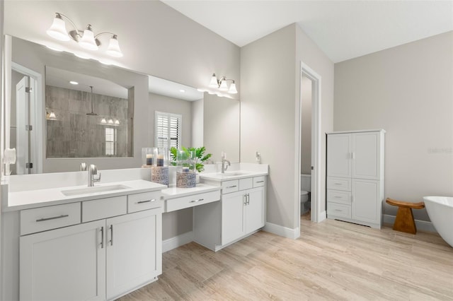 full bathroom featuring toilet, independent shower and bath, vanity, and wood-type flooring