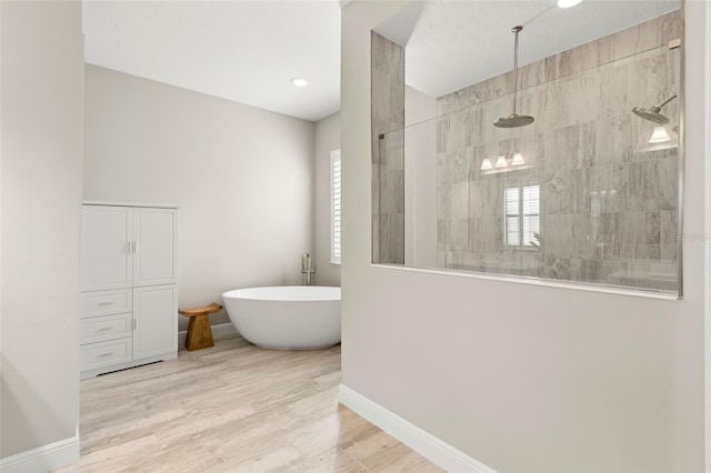 bathroom featuring hardwood / wood-style floors, a wealth of natural light, and independent shower and bath