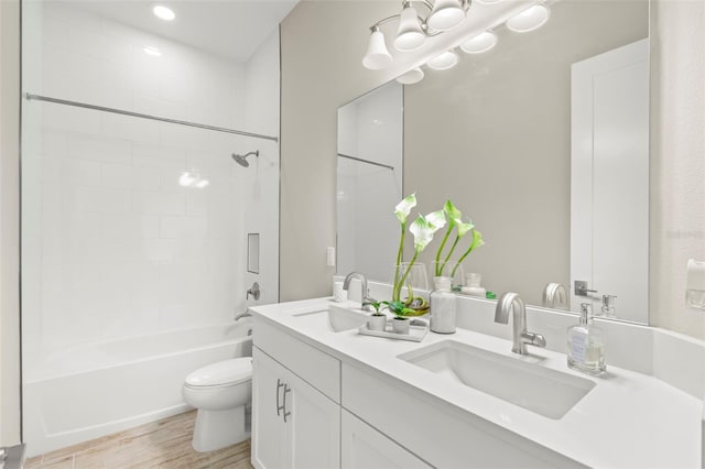 full bathroom featuring toilet, vanity, tiled shower / bath, and wood-type flooring