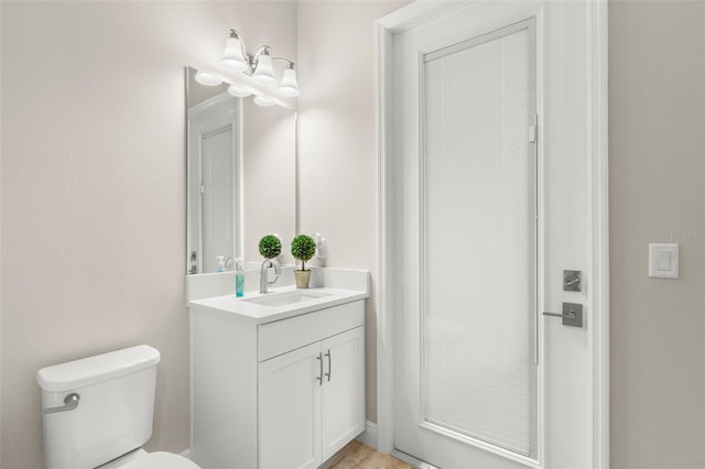 bathroom featuring hardwood / wood-style floors, vanity, and toilet