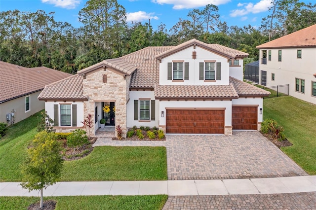 mediterranean / spanish-style home featuring a garage and a front lawn