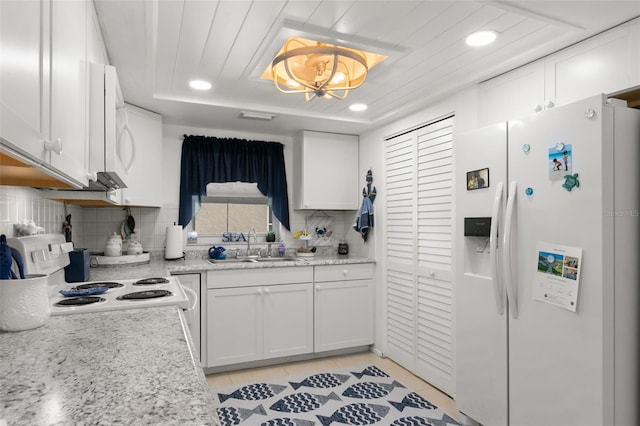 kitchen featuring white appliances, tasteful backsplash, white cabinetry, and sink