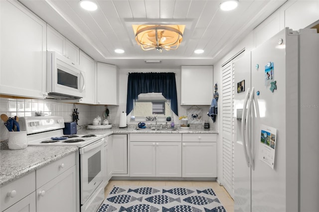 kitchen with backsplash, sink, white cabinets, and white appliances