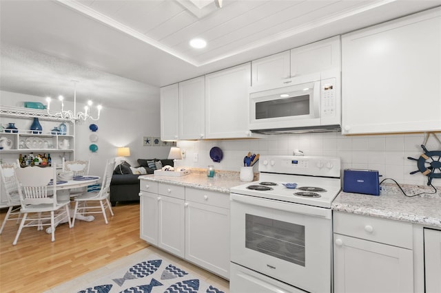 kitchen with white cabinets, decorative backsplash, white appliances, and light hardwood / wood-style floors