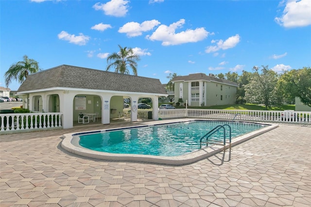 view of pool featuring an outbuilding and a patio