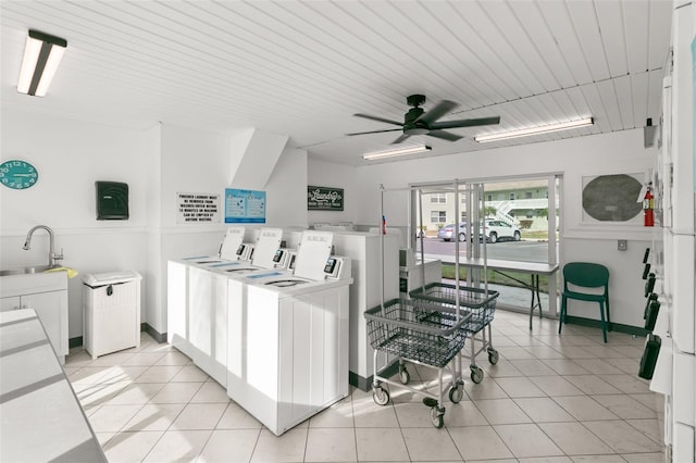 laundry area featuring ceiling fan, washing machine and dryer, light tile patterned floors, and sink