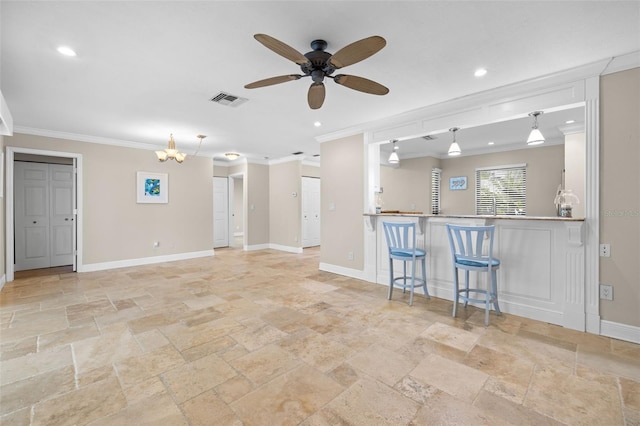 unfurnished living room with bar, ceiling fan with notable chandelier, and ornamental molding