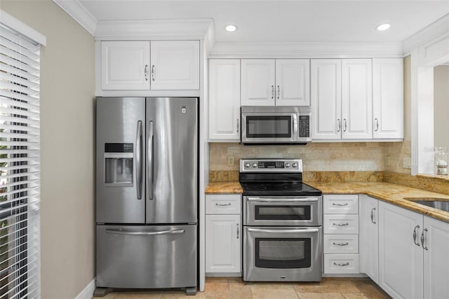 kitchen with stainless steel appliances, white cabinets, ornamental molding, backsplash, and light stone countertops