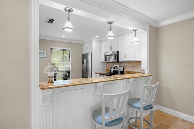 kitchen featuring white cabinetry, kitchen peninsula, light stone counters, appliances with stainless steel finishes, and a breakfast bar area