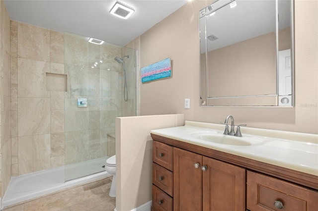 bathroom featuring a tile shower, vanity, tile patterned floors, and toilet