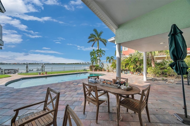 view of swimming pool with a patio area and a water view