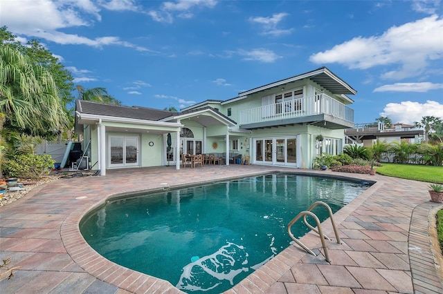 back of house featuring a balcony, french doors, and a patio area