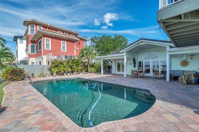 view of swimming pool with a patio and french doors