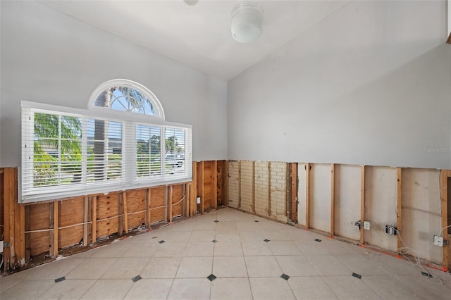 empty room featuring high vaulted ceiling and plenty of natural light