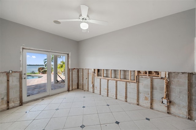 spare room featuring a water view, french doors, and ceiling fan