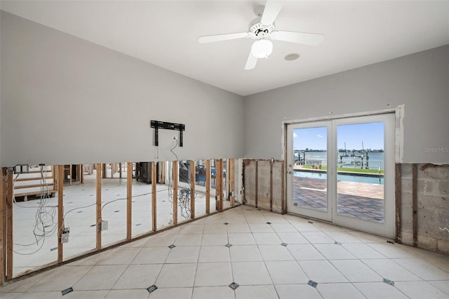 empty room featuring ceiling fan and a water view