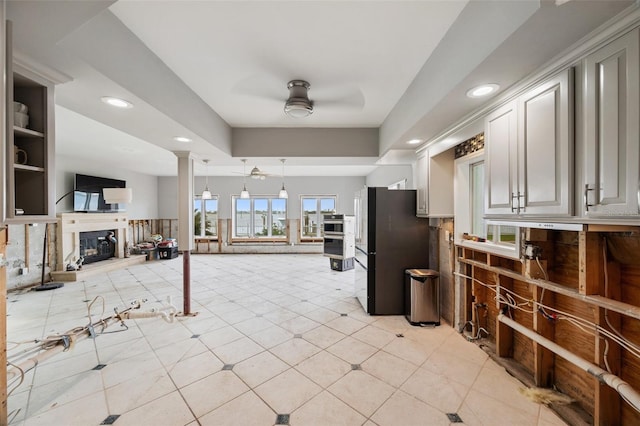 kitchen featuring ornate columns, refrigerator, hanging light fixtures, light tile patterned flooring, and ceiling fan