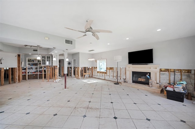 unfurnished living room with a tiled fireplace and ceiling fan