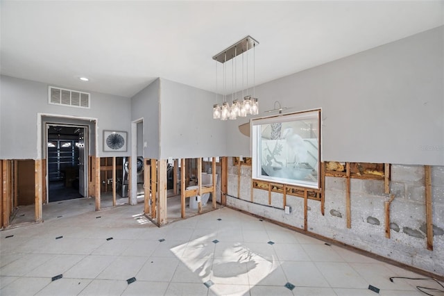 unfurnished dining area featuring a chandelier