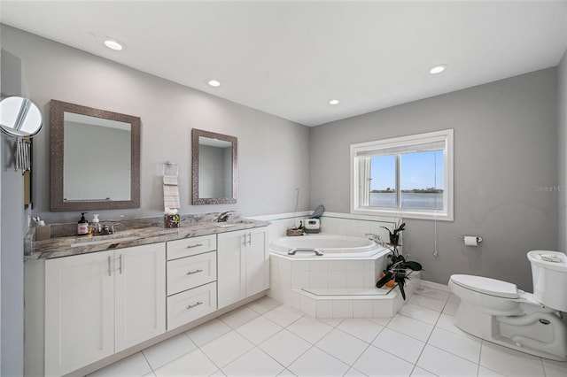 bathroom featuring toilet, vanity, tiled bath, and tile patterned flooring