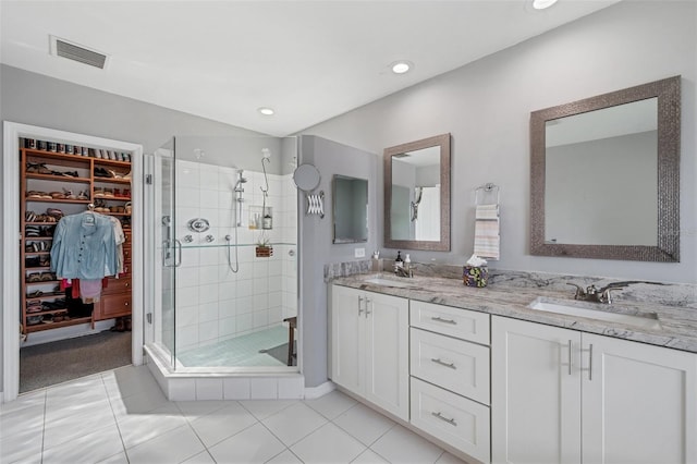 bathroom featuring vanity, a shower with door, and tile patterned floors