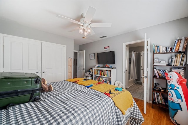 bedroom featuring wood-type flooring, ceiling fan, and a closet