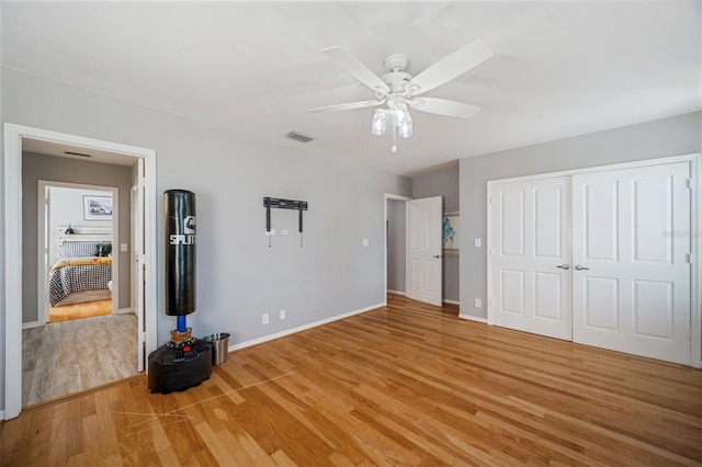 unfurnished bedroom with ceiling fan, a closet, and wood-type flooring