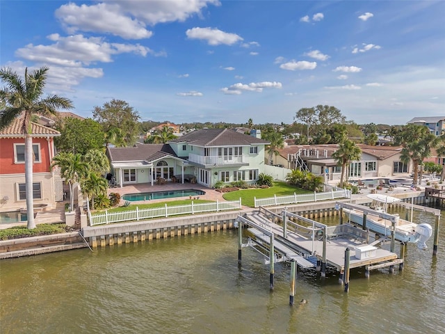 dock area with a patio area, a water view, and a lawn