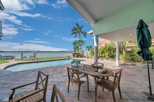 view of swimming pool with a patio and a water view