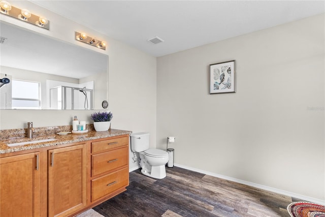 bathroom with vanity, hardwood / wood-style flooring, toilet, and walk in shower