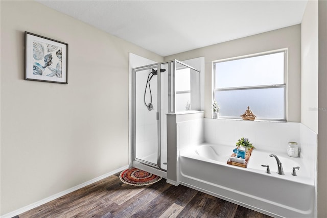 bathroom with wood-type flooring and shower with separate bathtub