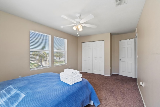 bedroom with ceiling fan, a closet, and dark colored carpet