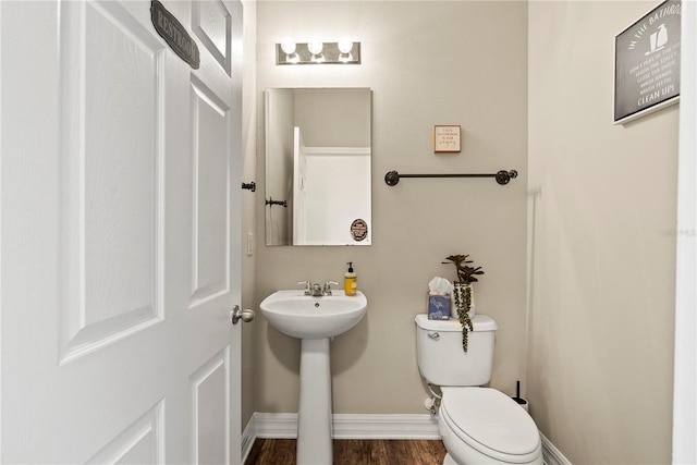 bathroom featuring toilet, wood-type flooring, and sink