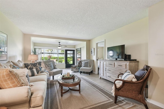 living room featuring a textured ceiling, ceiling fan, and light tile patterned flooring