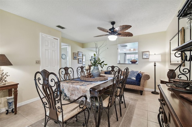 dining space with ceiling fan, light tile patterned floors, and a textured ceiling