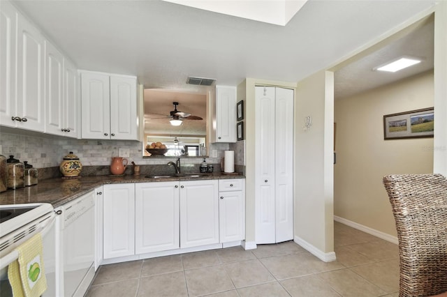 kitchen with white appliances, backsplash, sink, ceiling fan, and white cabinetry