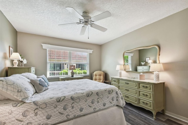 bedroom with a textured ceiling, ceiling fan, and dark hardwood / wood-style floors