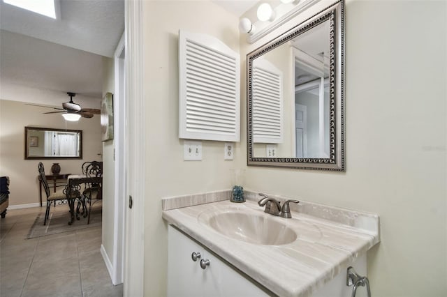 bathroom with a textured ceiling, vanity, tile patterned floors, and ceiling fan