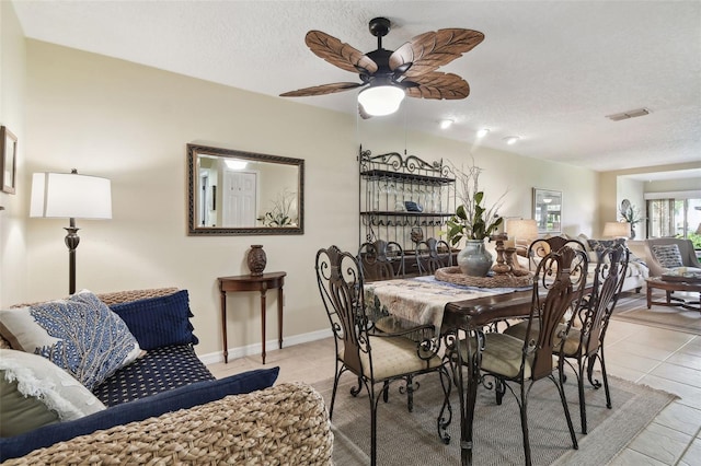 dining area featuring ceiling fan, light tile patterned floors, and a textured ceiling