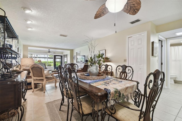 tiled dining space featuring ceiling fan and a textured ceiling