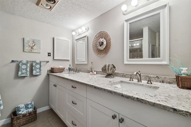 bathroom featuring tile patterned flooring, vanity, and a textured ceiling