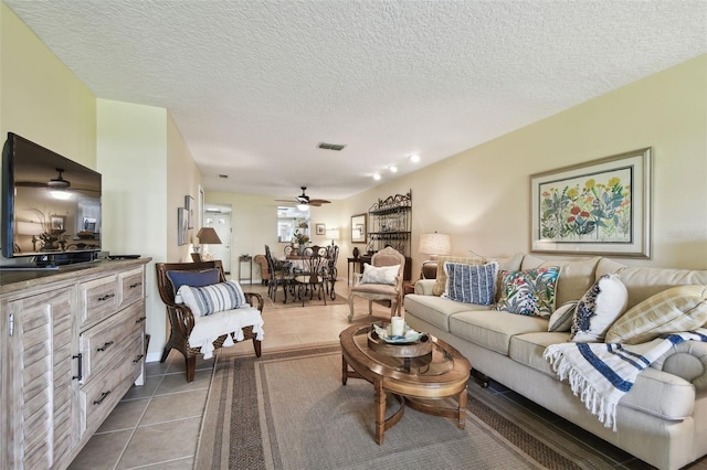 tiled living room featuring a textured ceiling and ceiling fan