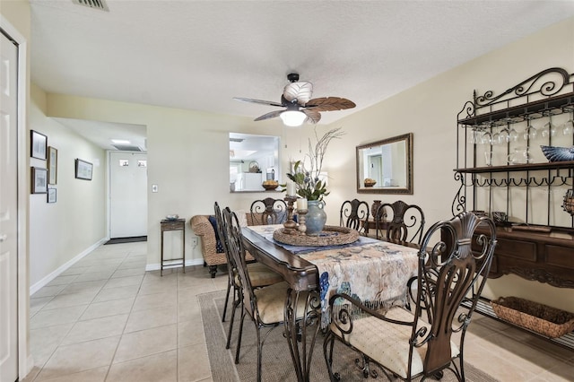 tiled dining area featuring a textured ceiling and ceiling fan