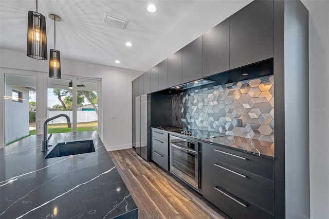 kitchen featuring sink, dark hardwood / wood-style flooring, oven, decorative light fixtures, and black electric stovetop